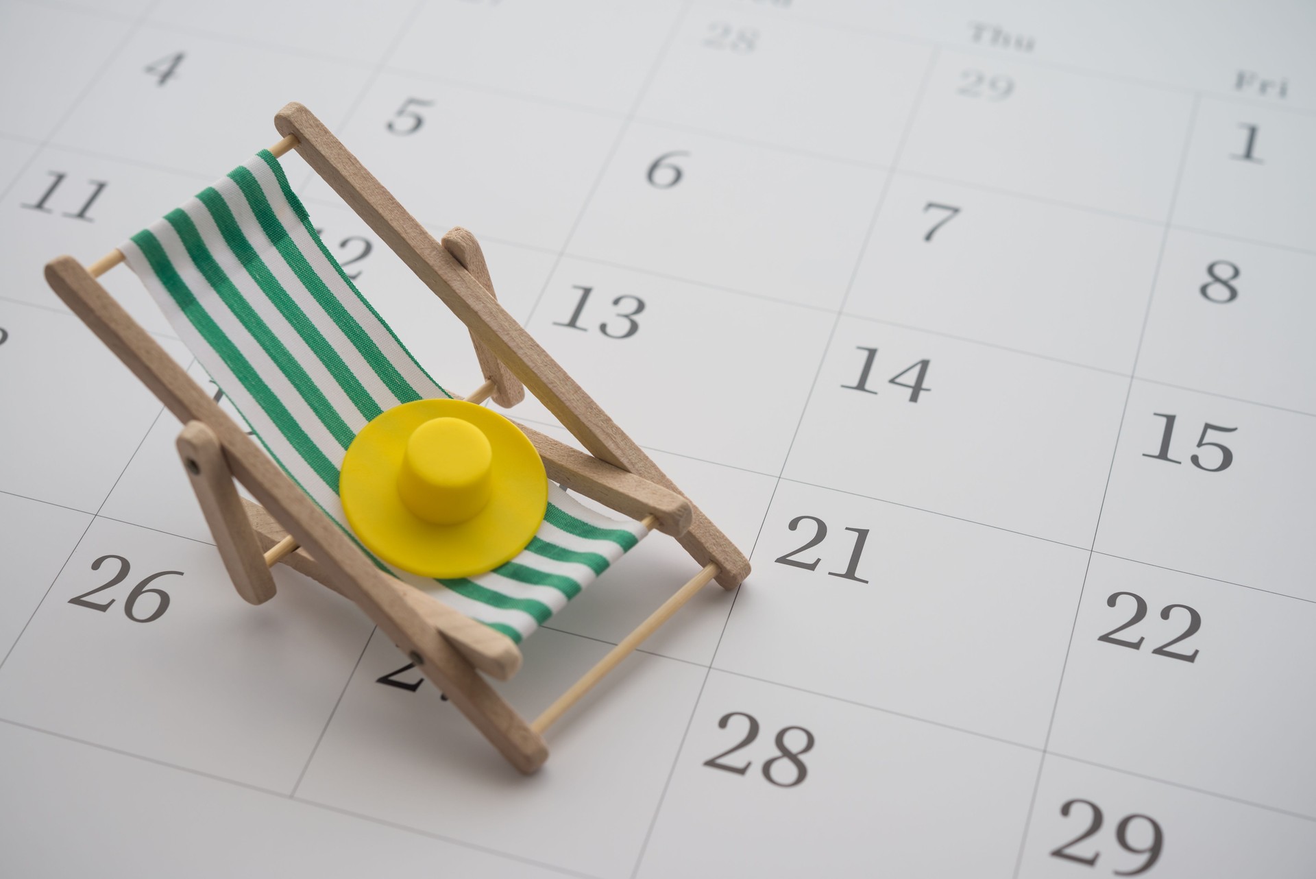 Green beach chair and hat on white blank calendar background copy space.